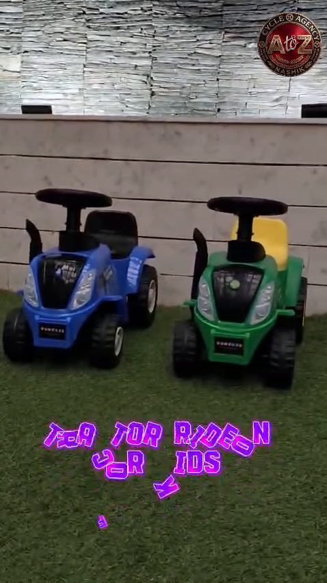 Blue and green Funfizz tractor ride-ons parked side by side on grass